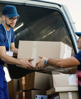 Młodzi kurierzy współpracują przy rozładunku paczek z dostawą